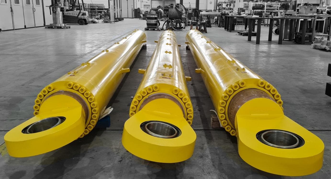 Grands vérins jaunes avec fixations à œil dans l’atelier