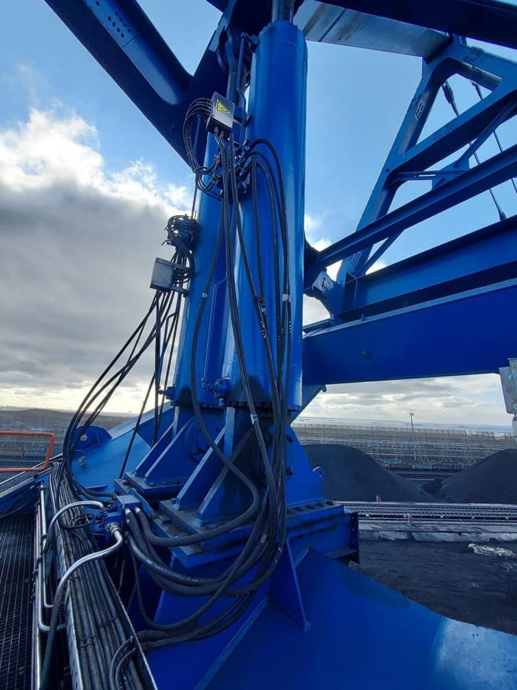 Détail des fixations et raccordements hydrauliques du vérin sur le stacker-reclaimer