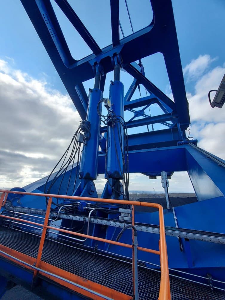 Paire de vérins montés dans la structure bleue du stacker-reclaimer