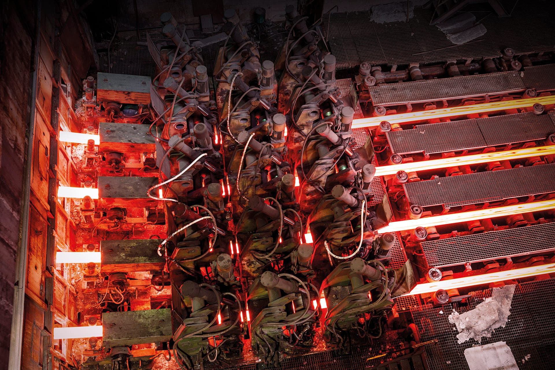 Glowing hot steel sections on a rolling line seen from above