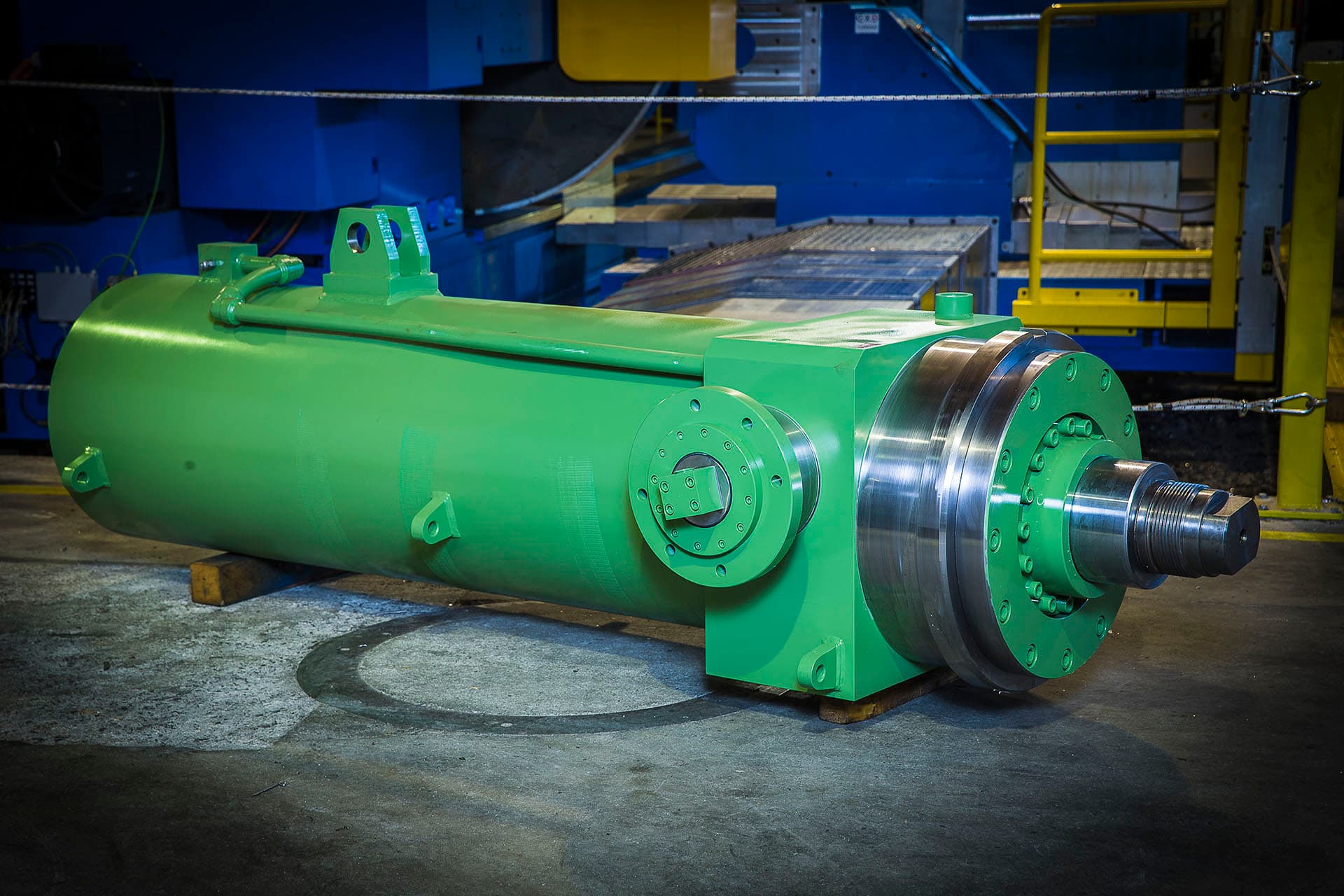 Green cylinder with a polished rod in front of a blue test bench