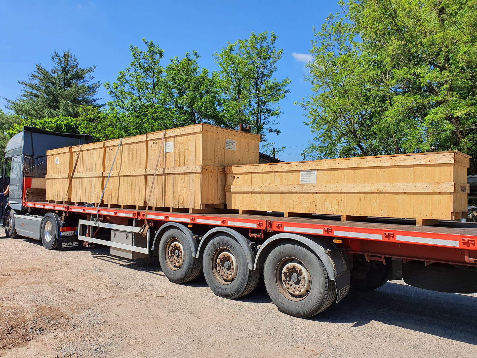 Truck carrying two large wooden crates on a flatbed trailer