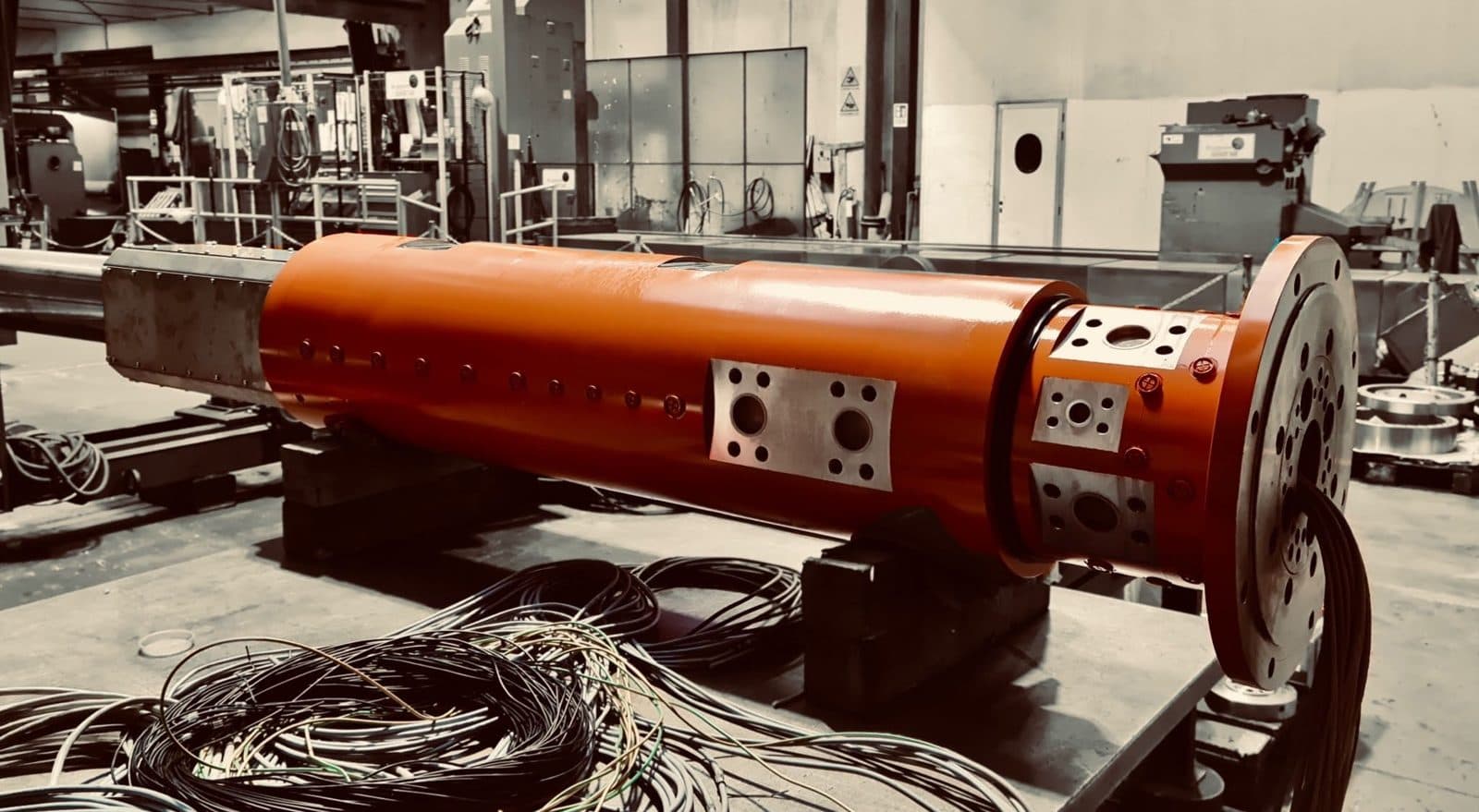 Distributore rotante arancione con cavi elettrici, in officina