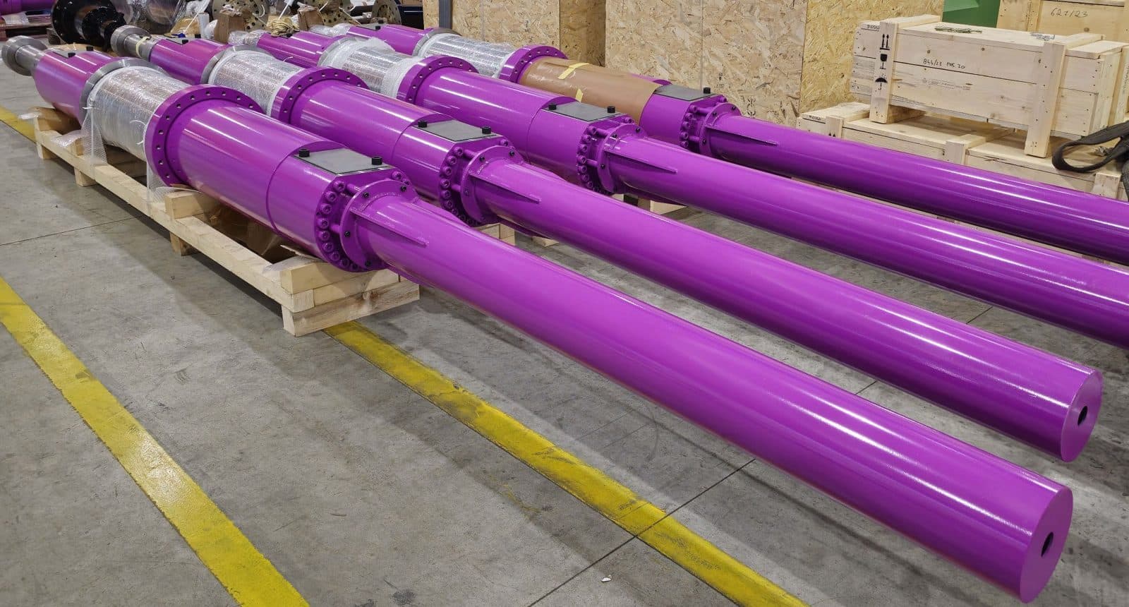Purple extrusion press cylinders lined up on the floor