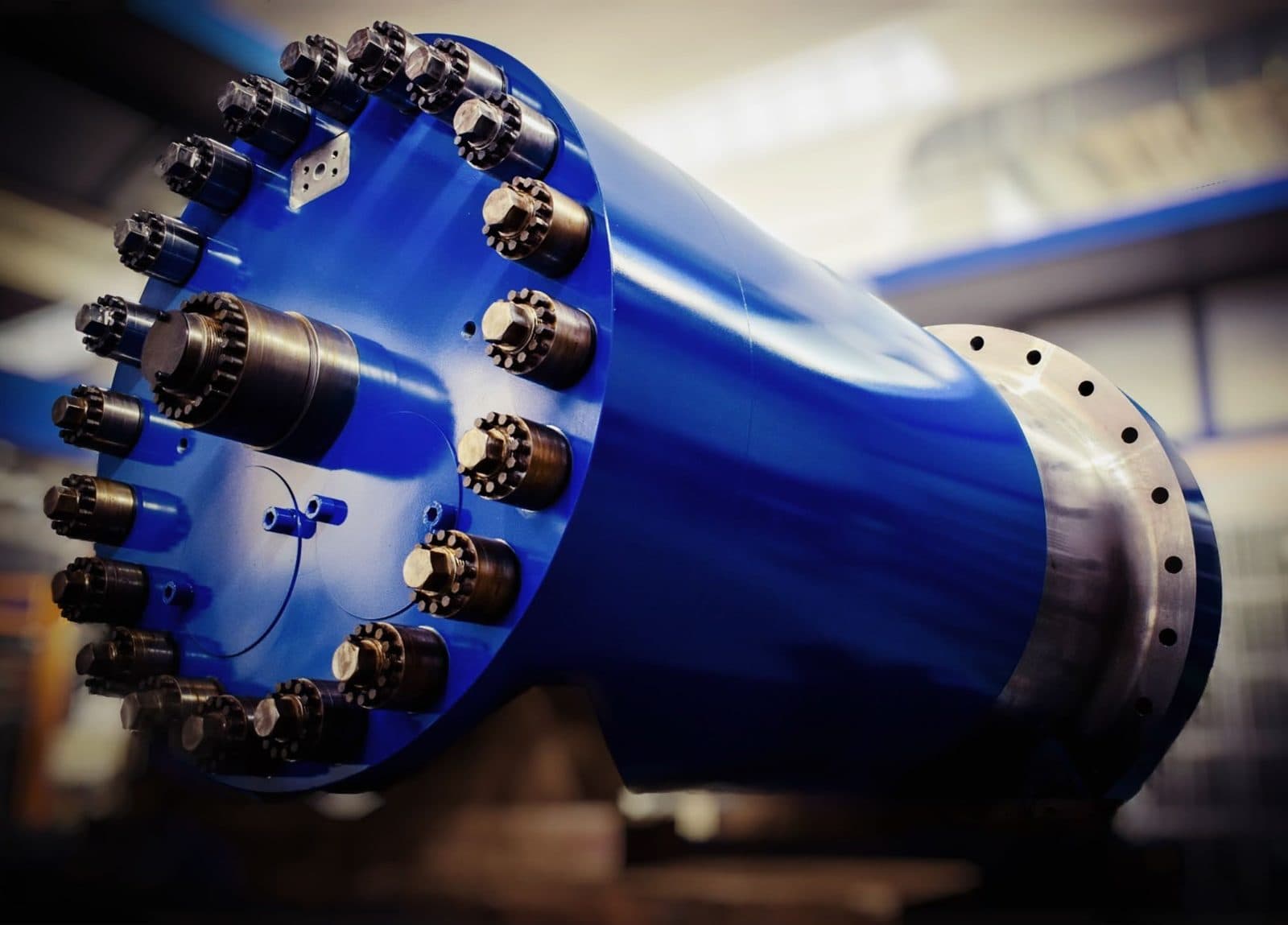 Blue press main cylinder with a large ring of nuts