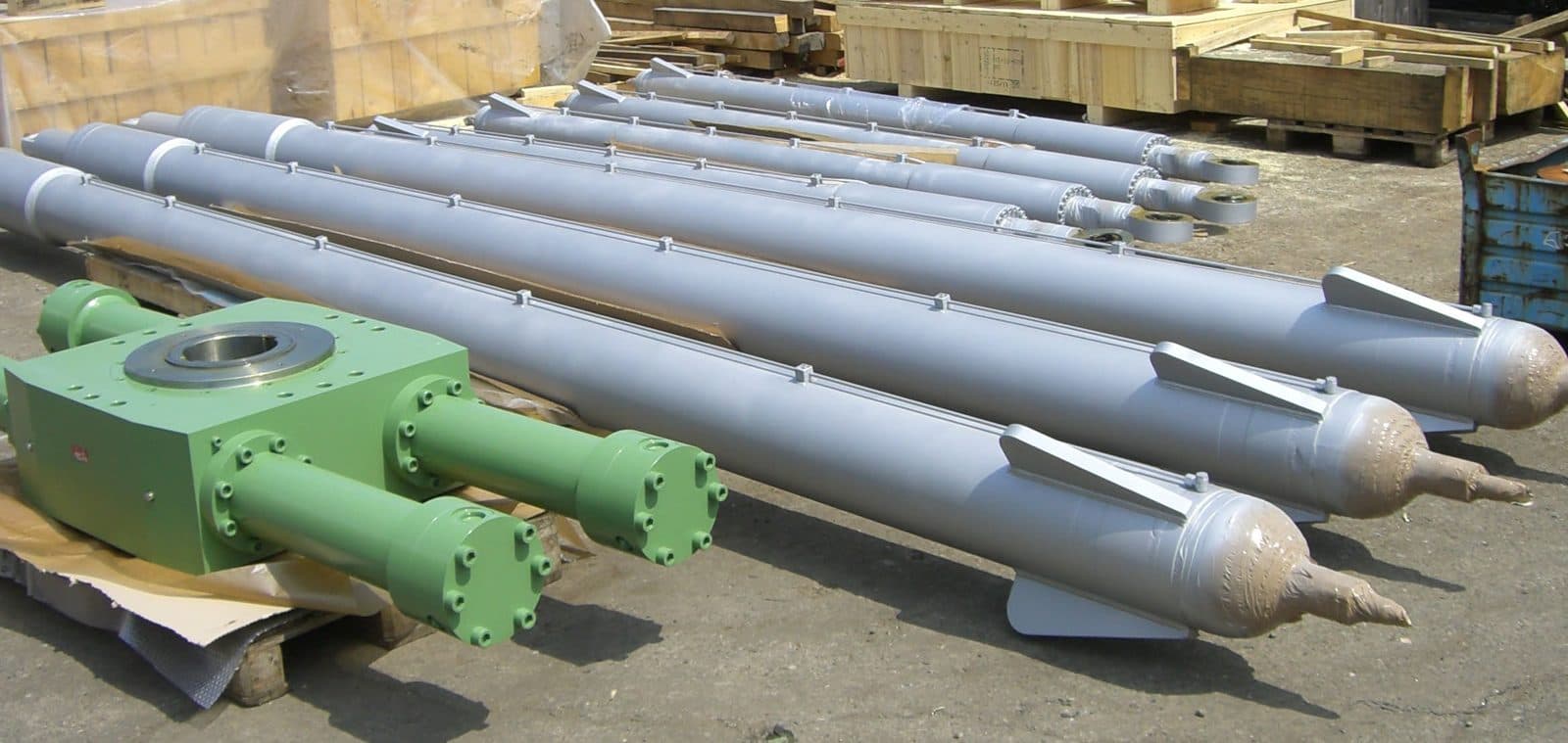 Long grey electrode lifting cylinders resting on pallets
