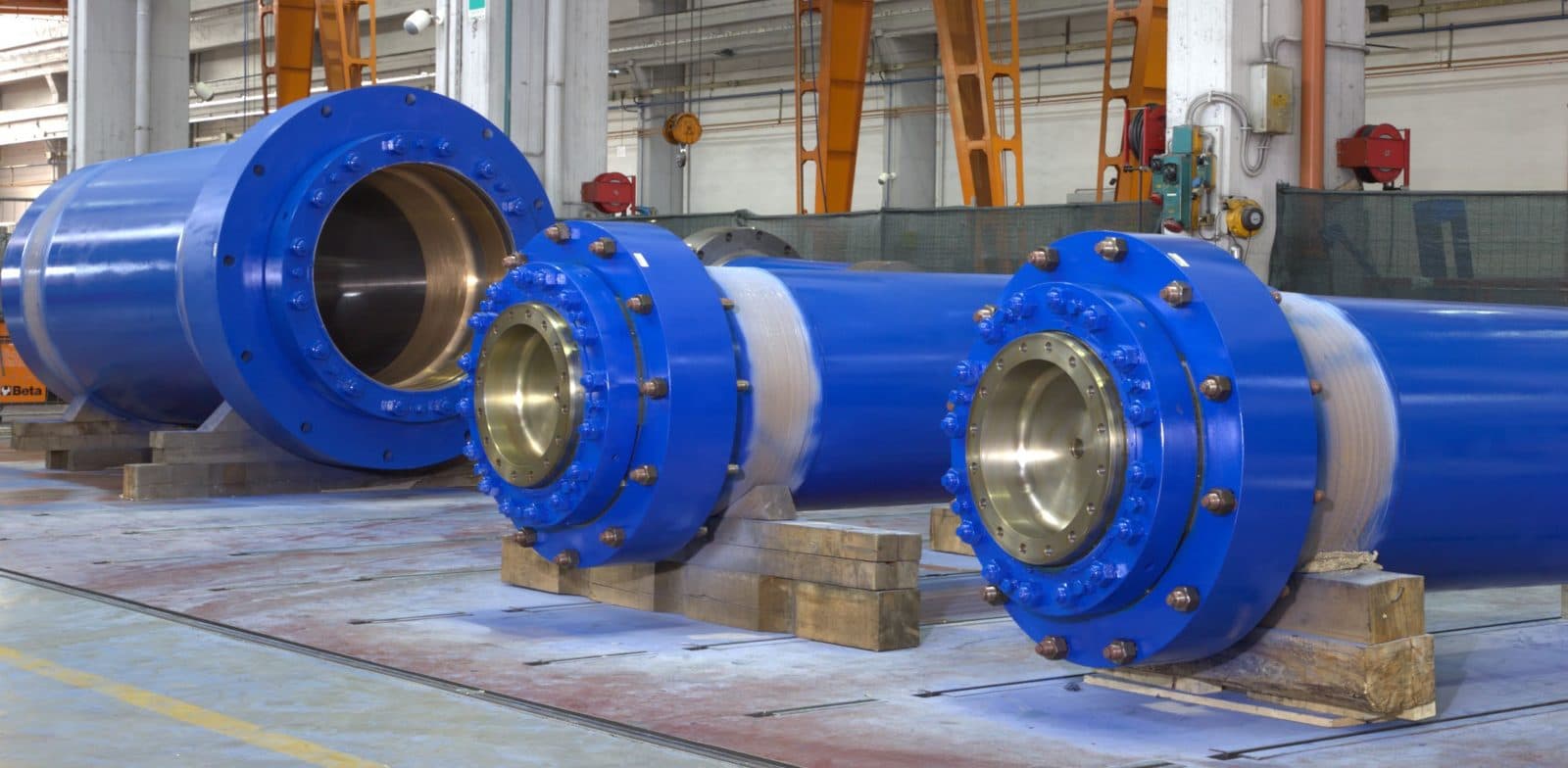 Large blue open-die press cylinders with bronze bushings
