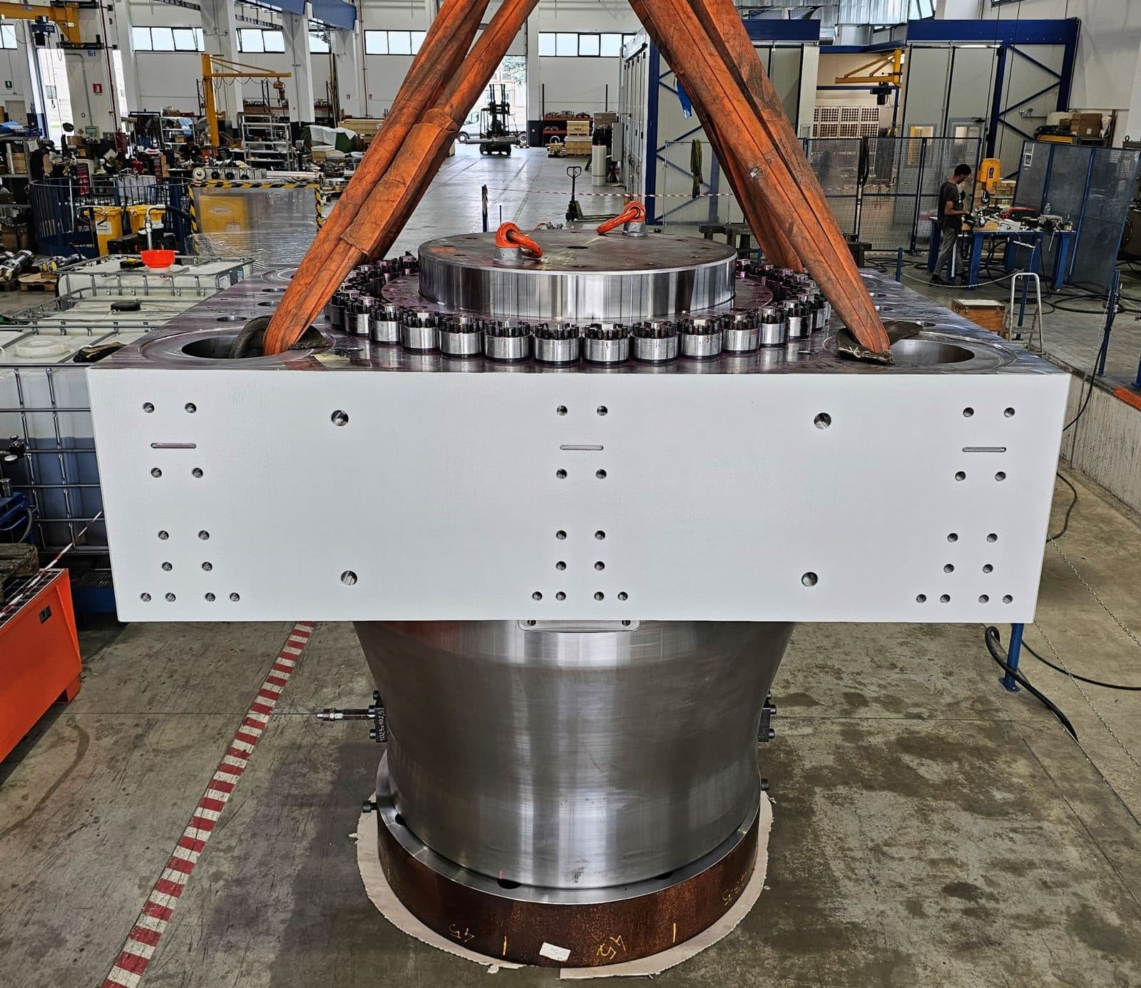 Closed-die press main cylinder hanging from the crane in the workshop