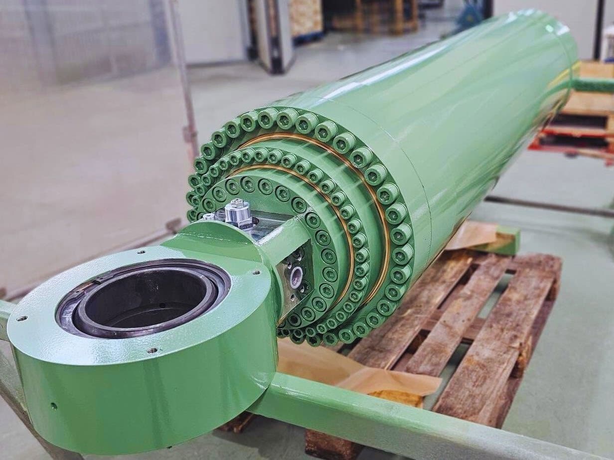 Green telescopic cylinder with an eye and a ring of screws, on a pallet