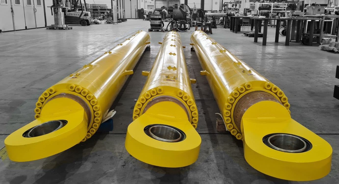 Three yellow tensioning cylinders with eyes in the workshop