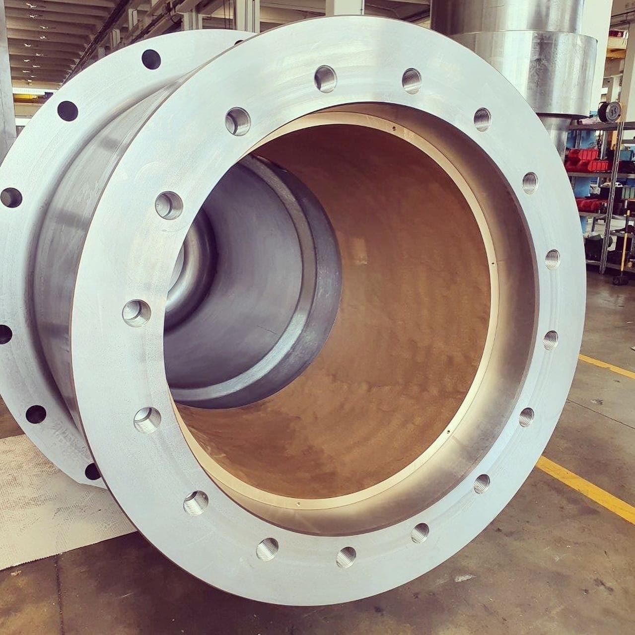 Inside of a large cylinder barrel with a bronze-coloured bore and a flange