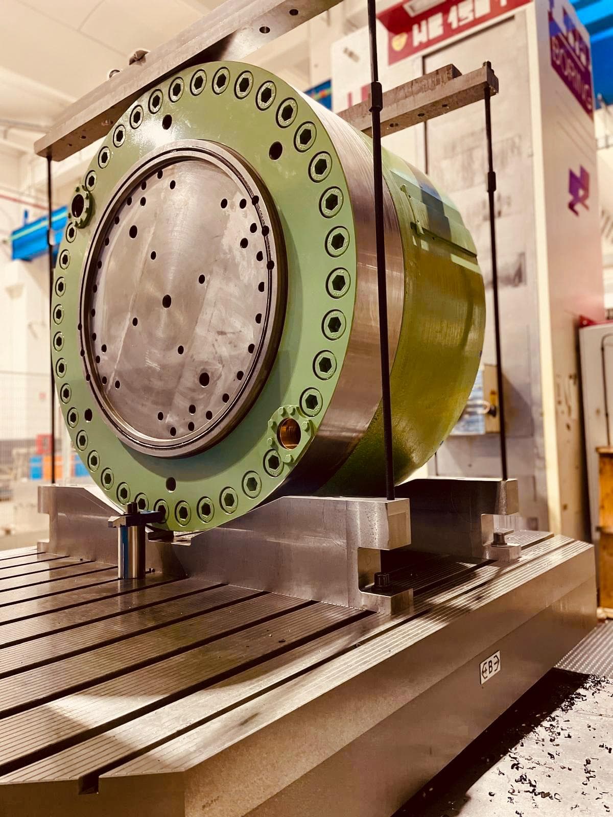 Large green capsule being machined on a machine tool table