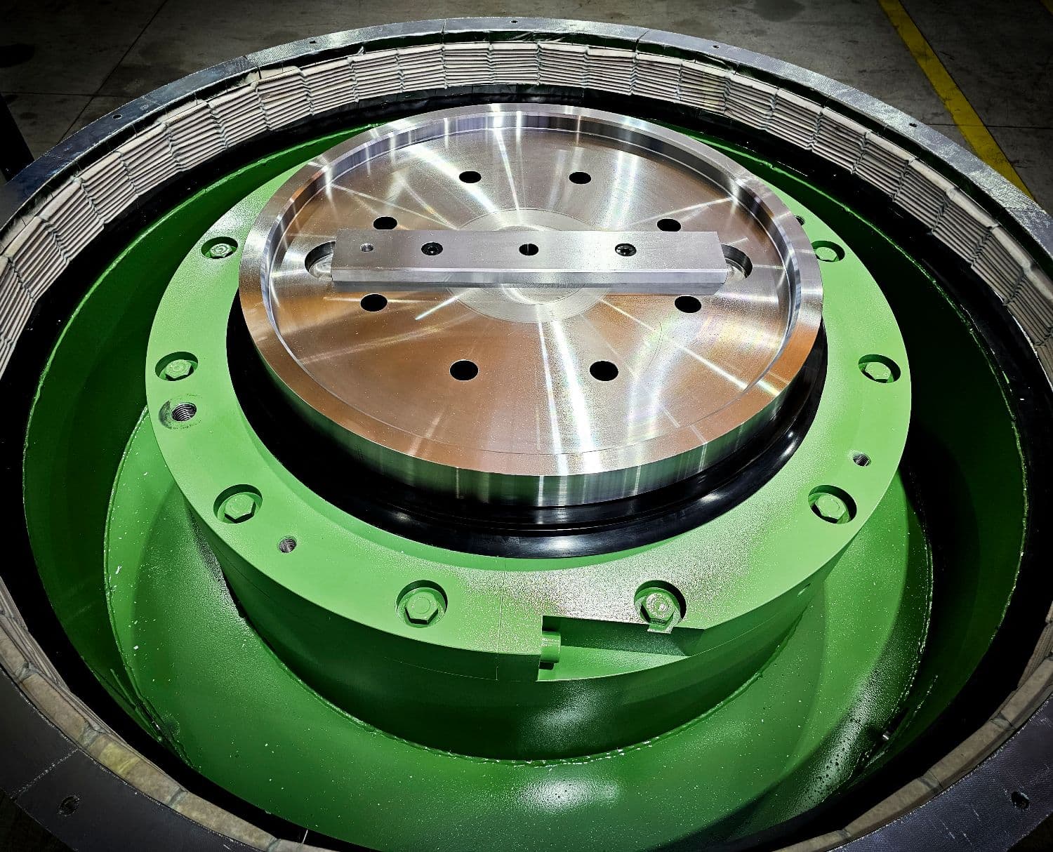 Green hydraulic capsule seen from above, the machined piston in its seals