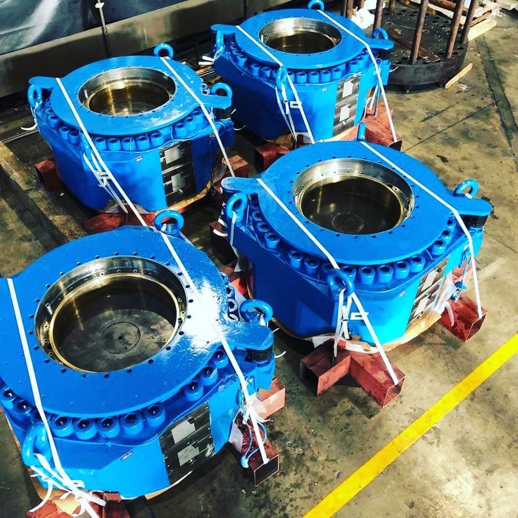 Four blue hydraulic capsules strapped on supports, ready for shipment