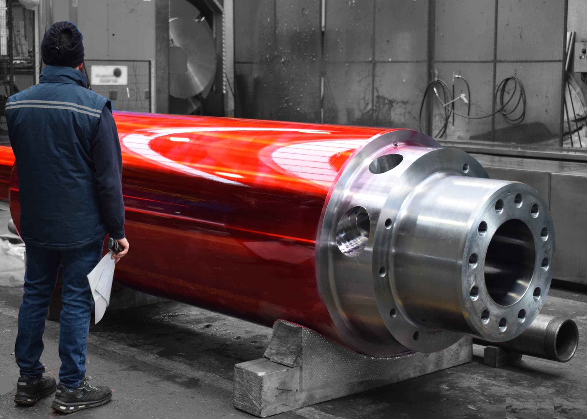Technician beside a large red cylinder with a steel flange