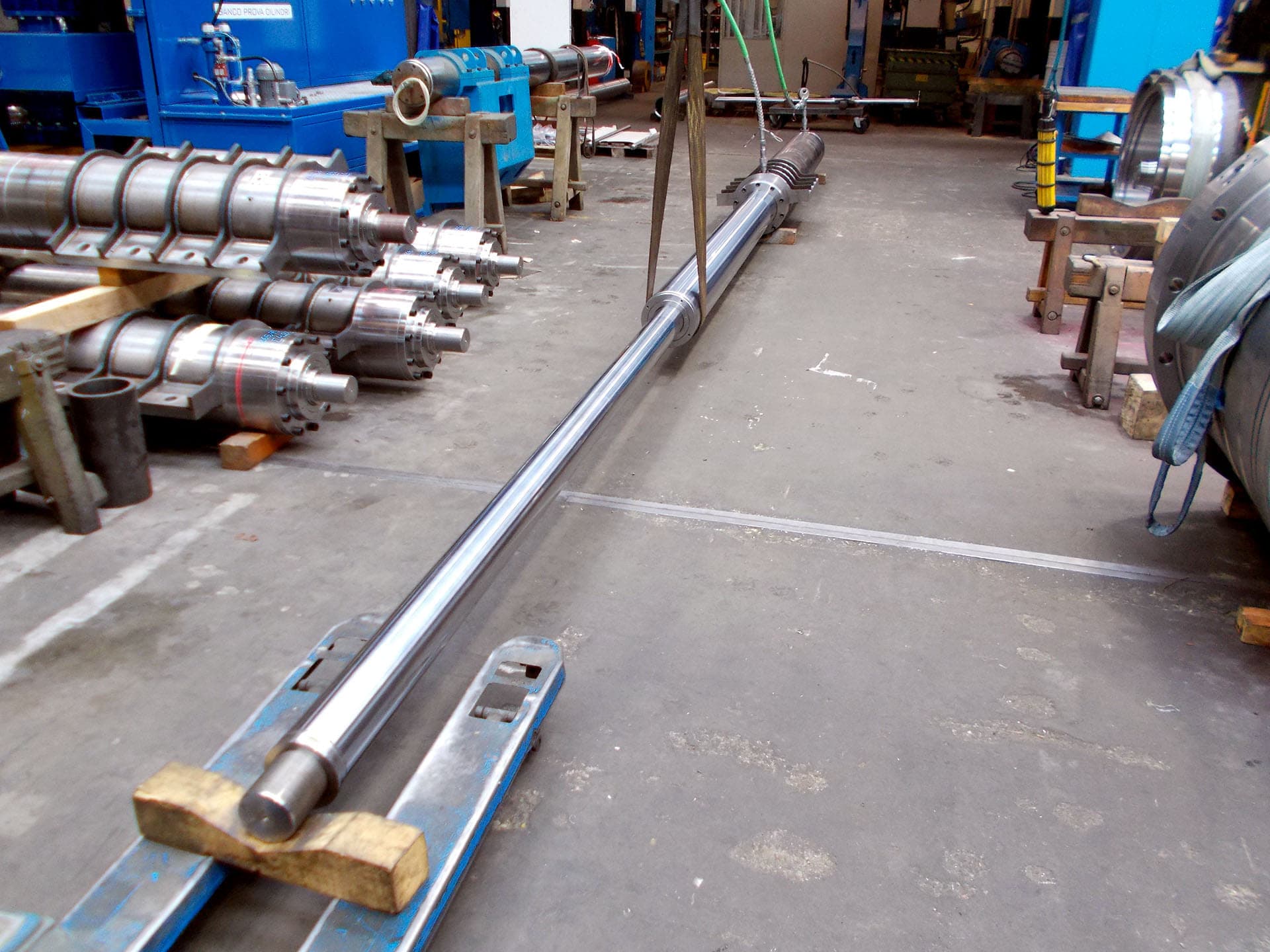 Very long chrome rod on the floor of a workshop aisle