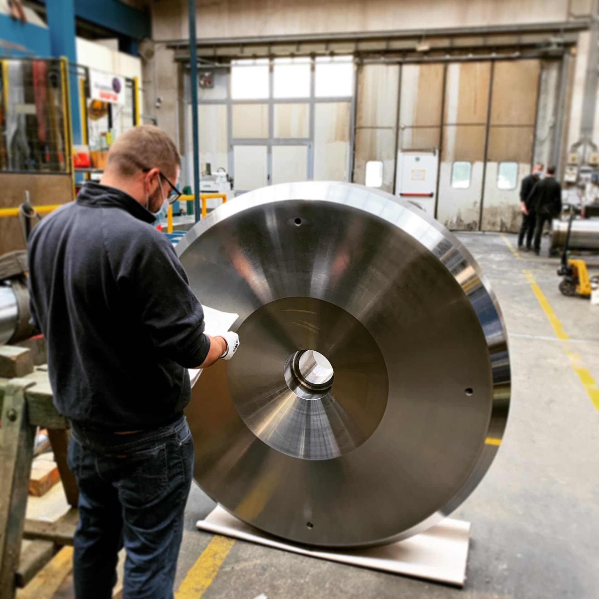 Operator inspecting the face of a large circular steel part