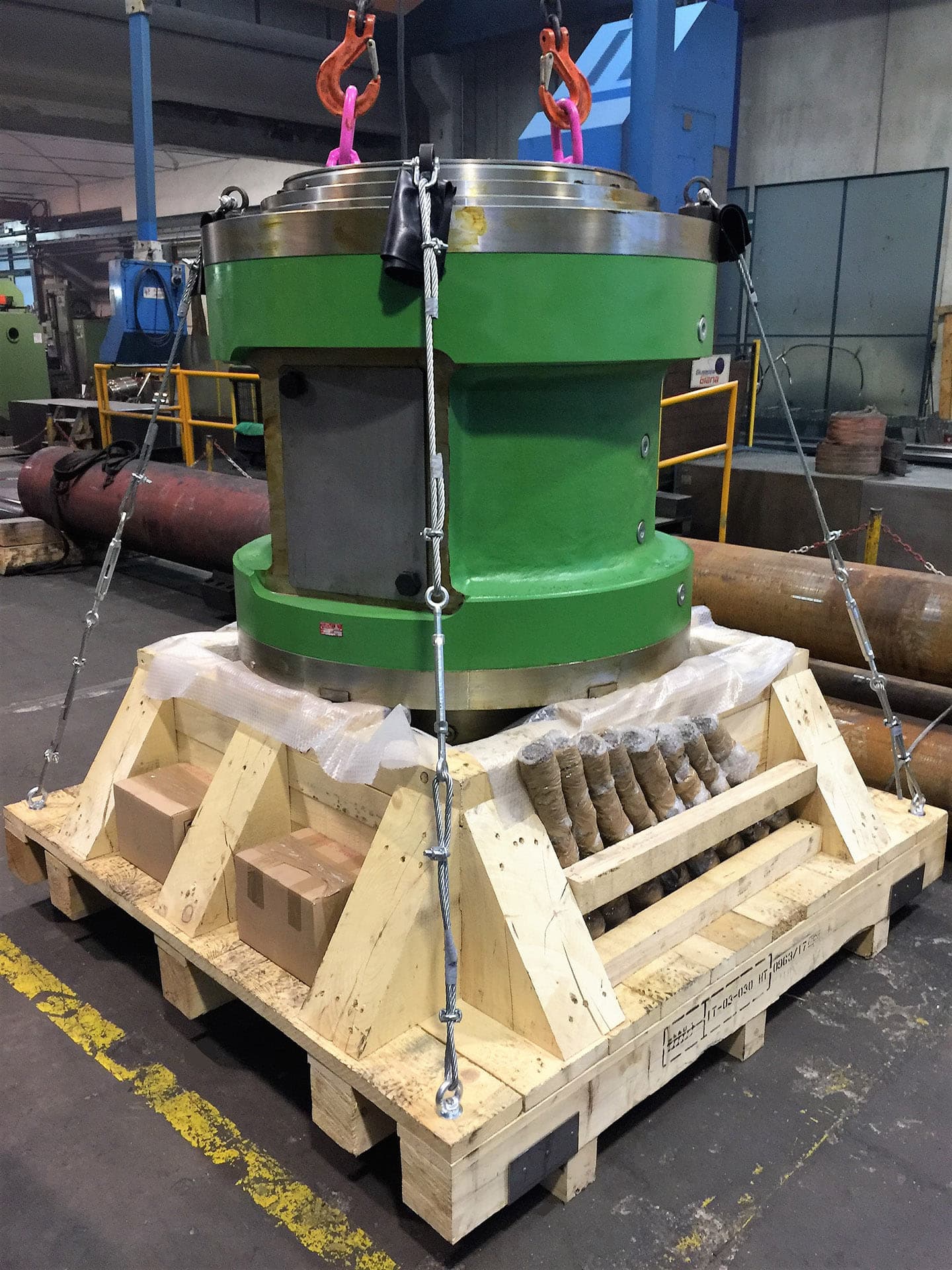 Large green cylinder braced with wooden blocks and straps for transport