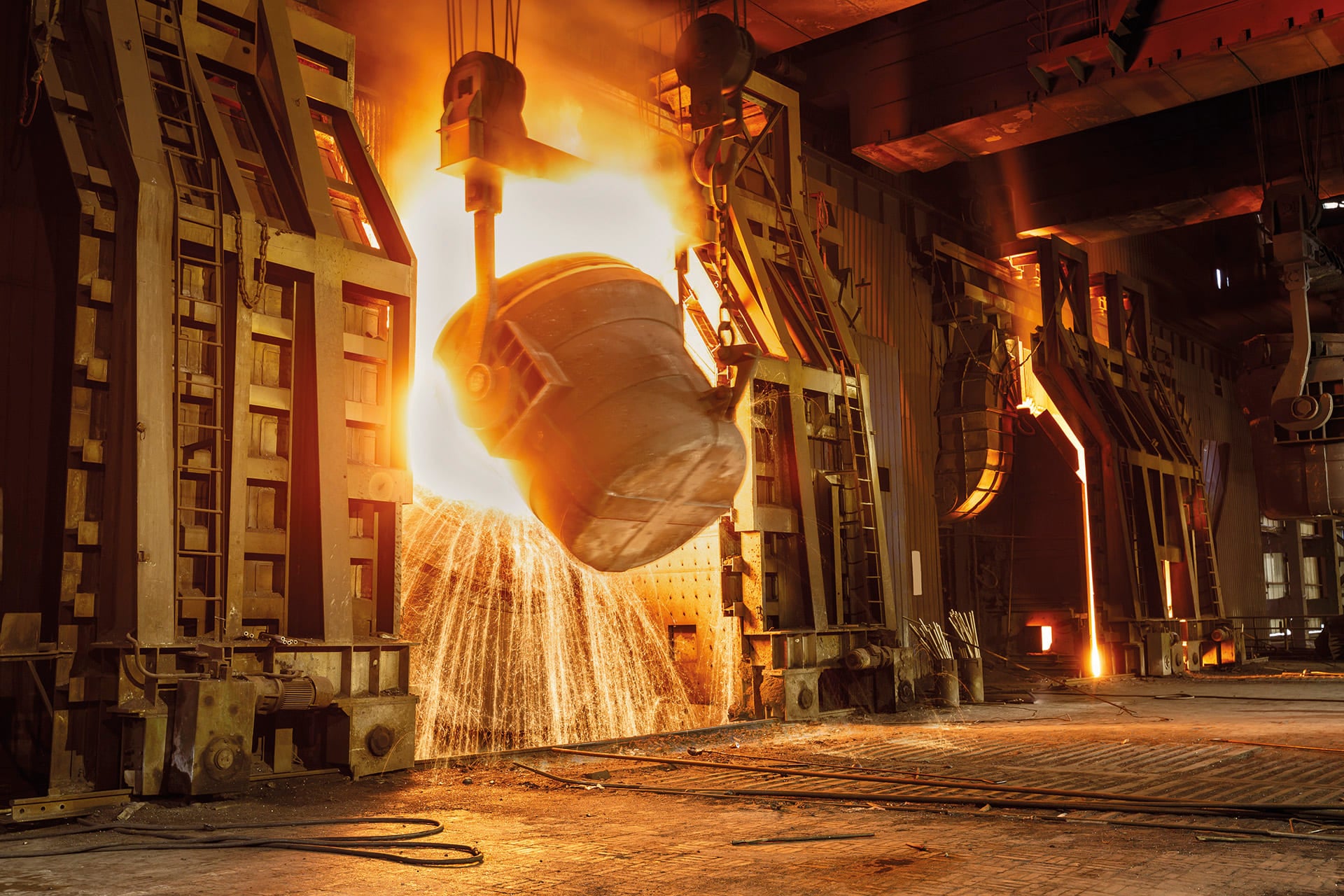 Ladle pouring molten steel in a steelworks with flying sparks