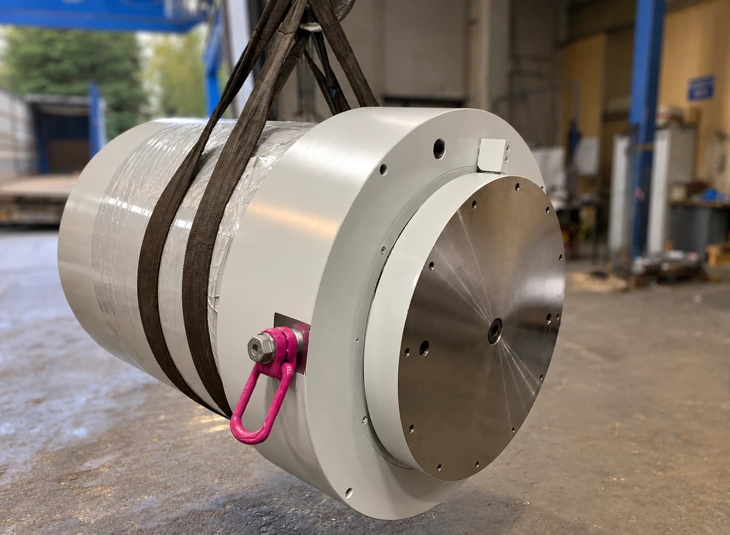 Cylinder lifted by grey straps with a pink lifting shackle