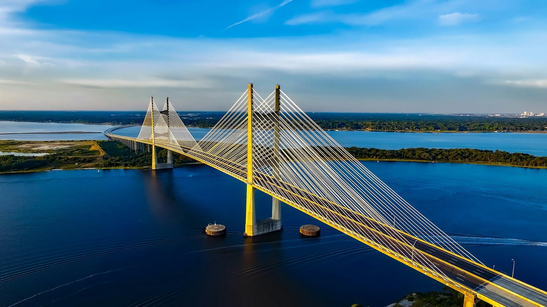 Cable-stayed bridge with yellow stay cables over a wide river